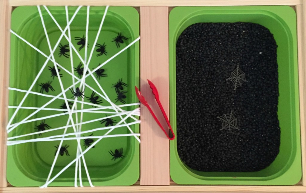 Spider sensory bin with spiders, tongs, and yarn web. Spider fine motor activity 